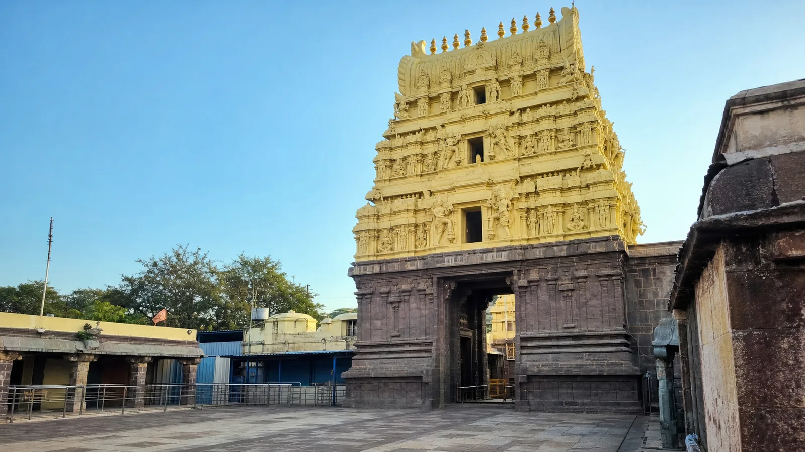 Present-day Mallikarjuna Swamy Temple entrance gopuram at Srisailam in Andhra Pradesh, with a yellow Dravidian tower on a dark stone base.